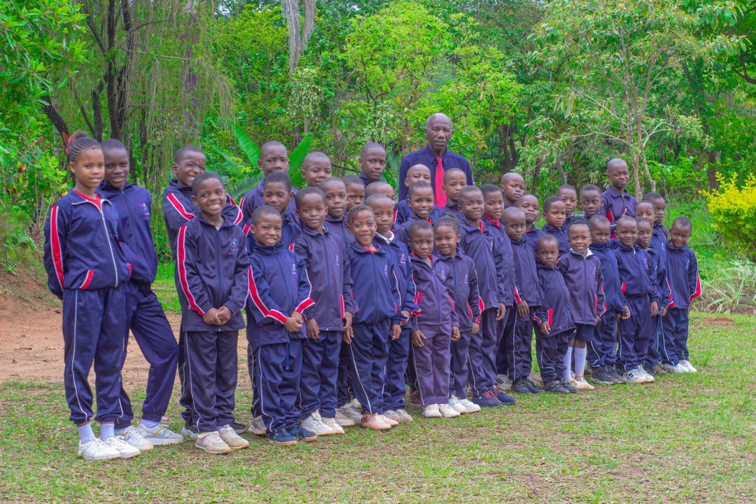 Bethel College learners standing outdoors in navy school tracksuits