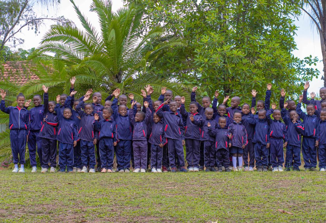 A group of Bethel College learners gathered beneath a palm tree
