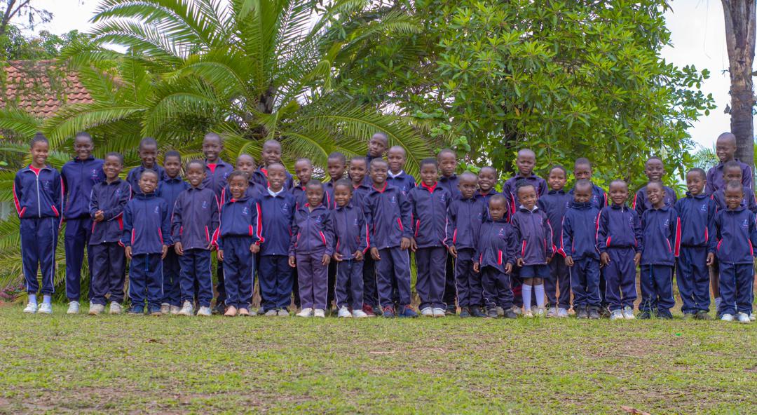 A wide group photograph of Bethel College learners outdoors