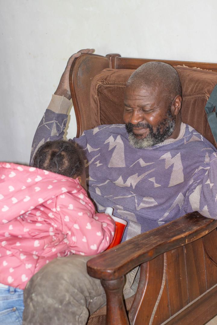An adult seated with a young child during a quiet moment