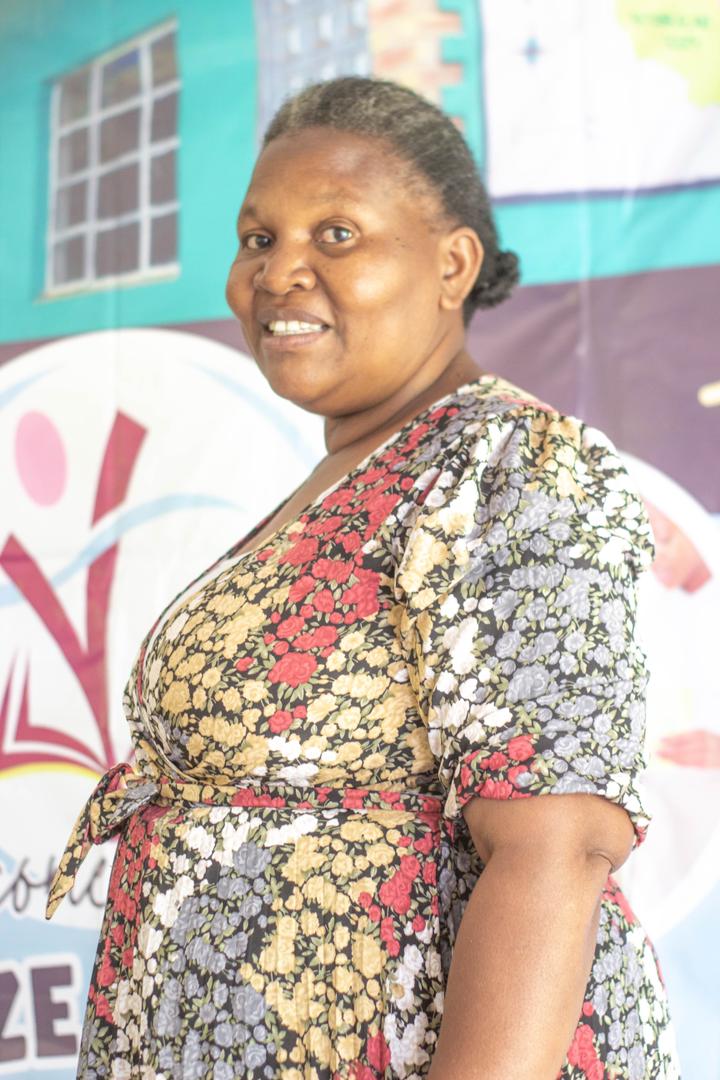 A member of the school community standing near the school banner