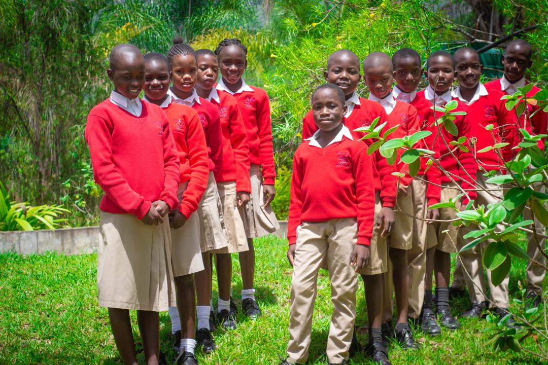 Bethel College learners in red jerseys standing outside